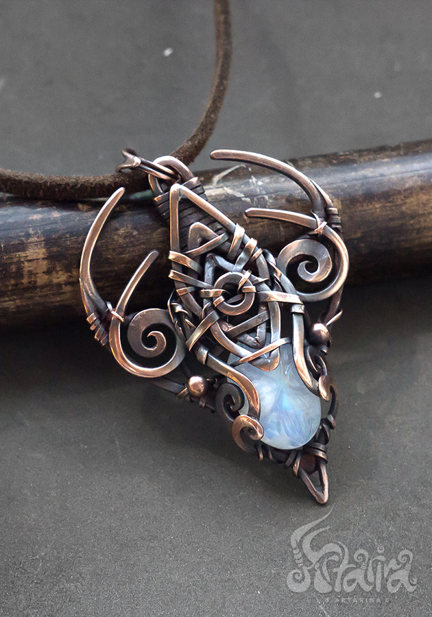 Copper wire wrapped pendant with carved moonstone.