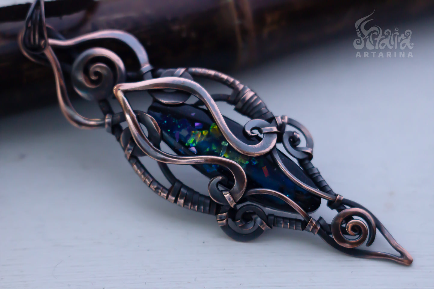 Ornate metal brooch with dark gemstone on a light background