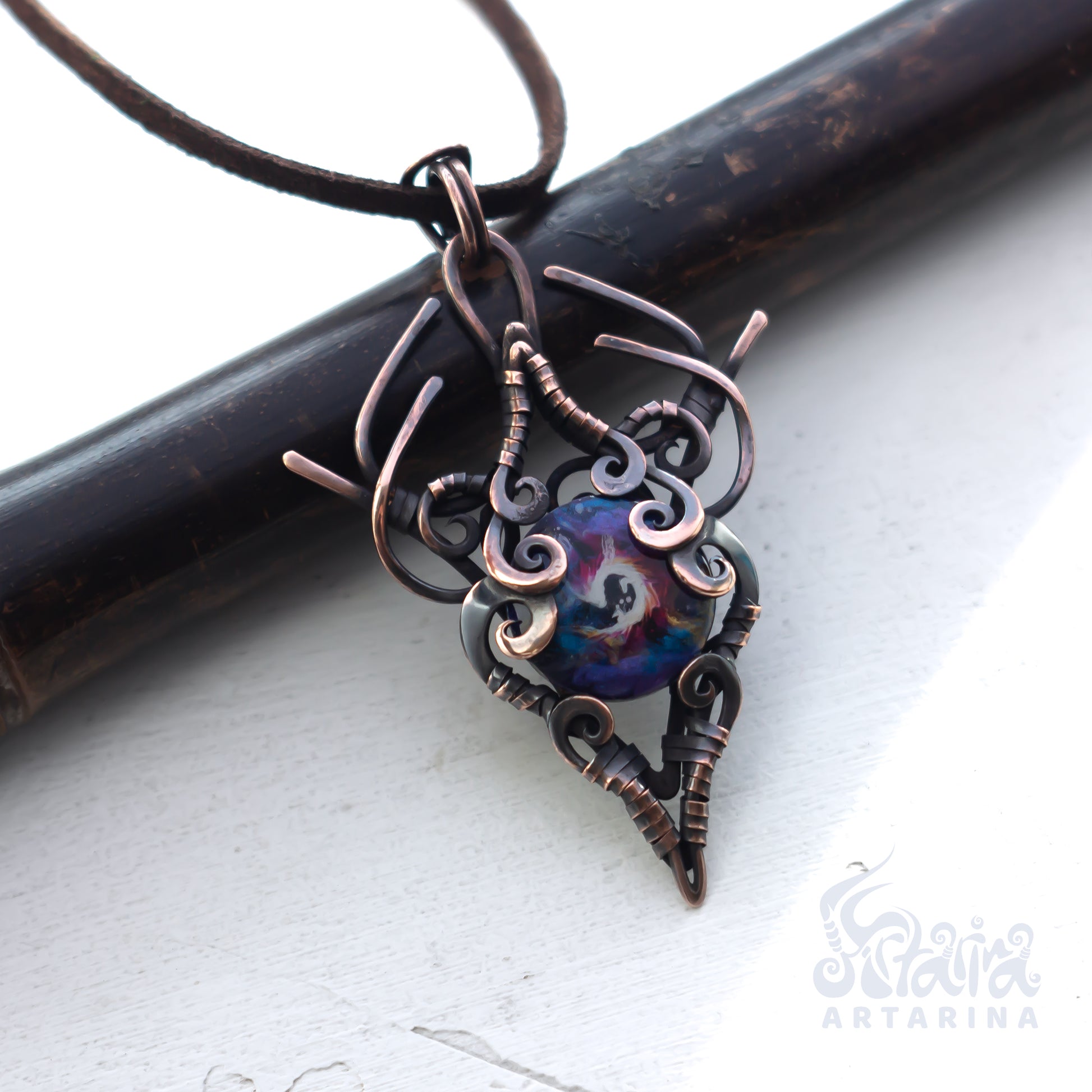 Copper pendant with a colorful heart-shaped center on a white background