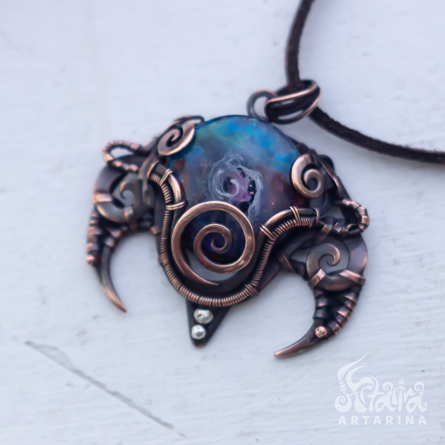 Ornate pendant with copper accents on a light background